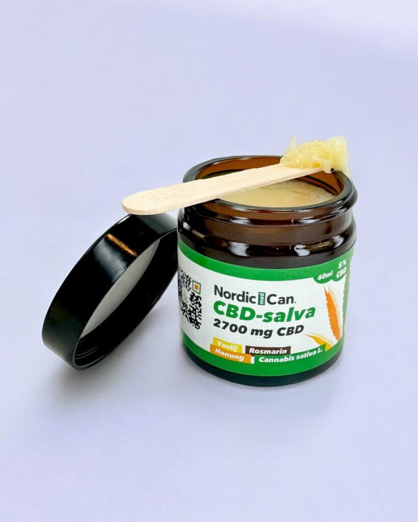 Produktbild på öppen burk CBD-salva med 5% CBD, honung, vanilj och rosmarin.